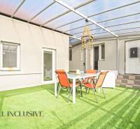 A Veľké Kosihy-i családi ház terasza műfűvel és kerti bútorokkal.