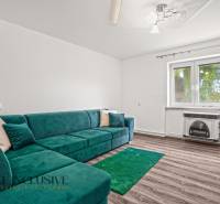 Nappali egy családi házban türkiz kanapéval és fa dekorációjú padlóval.