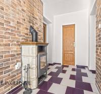 Családi ház belső tere cserépkályhával és téglafalakkal.