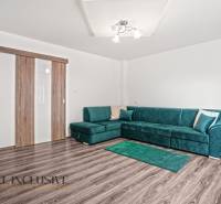 Nappali egy családi házban kanapéval és fa dekorációjú padlóval.