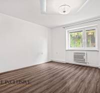 Egy családi ház szobája fa dekoros padlóval és fehér falakkal.