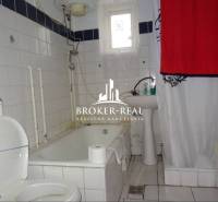 Fürdőszoba káddal és fehér csempékkel egy családi házban.