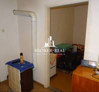 Családi ház belső tere fűtőtesttel, bútorokkal és fa dekorációjú padlóval.