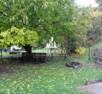 Családi ház kertje Fonyban, raklapokból készült ülőgarnitúrával és tűzrakóhellyel.