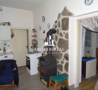 Konyha családi házban tűzhellyel, kemencével és kőburkolattal a falnál.