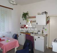 Konyha családi házban klasszikus berendezéssel, függönyök, fehér konyhabútor.