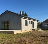 Családi ház Tesárske Mlyňany-ban vakolatlan homlokzattal és beton terasszal.