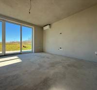 Tágas szoba egy családi házban nagy ablakokkal és kilátással a kertre.