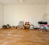 Egy szoba családi házban, játékokkal teli falakkal és fa dekorációjú padlóval.