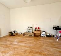 Egy szoba családi házban, fa dekoros padlóval és különböző tárgyakkal a falnál.