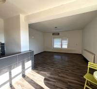 Családi ház belső tere tágas helyiséggel, fa dekorációjú padlóval és étkező sarokkal.