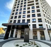 Magas épület a Kárpát utcában, Poprádon, modern bejárattal és íves járdákkal.