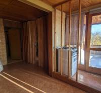 Családi ház belső tere teraszajtókkal és fa dekorációjú falakkal.