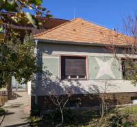 Családi ház Vrábléban, fákkal és zöld lombú kerttel körülvéve.