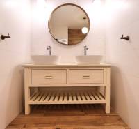 Fürdőszoba háromszobás lakásban, dupla mosdóval és fa mintázatú padlóval.