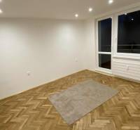 Szoba egy egyszobás lakásban fa dekorációjú padlóval és nagy ablakkal.