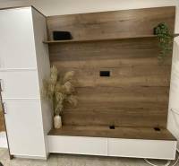 Az egyszobás lakásban van egy fa dekorációjú gardróbszekrény és egy váza virágokkal.