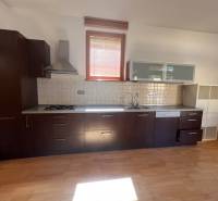 Konyha sötét szekrényekkel és készülékekkel a Moszkva utcai háromszobás lakásban.