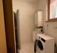 Mosókonyha egy 4 szobás lakásban mosógéppel, szárítógéppel és kazánnal, világos csempével.