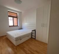 Hálószoba világos bútorokkal és fa dekorációjú padlóval egy 4 szobás lakásban.