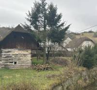 Faház a patak mellett, fákkal körülvéve, fű a telken - vidéki élet.