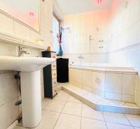 Fürdőszoba káddal, mosdóval és csempével egy kétszobás lakásban.