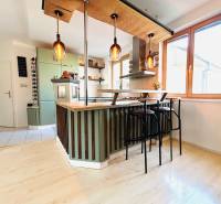 Konyha egy kétszobás lakásban bárpulttal és fa dekoros padlóval.