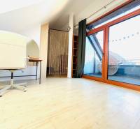 Dolgozószoba egy kétszobás lakásban, fa dekoros padlóval és erkélyajtóval.