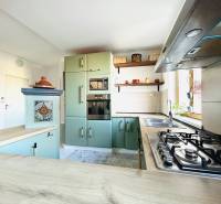 Konyha egy kétszobás lakásban gáztűzhellyel és díszített szekrényekkel.