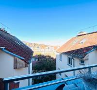 Kilátás az erkélyről a tetőkre és a város egy részére egy kétszobás lakásból.