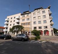 Épület a Komáromi Petőfi utcában, 4 szobás lakásokkal és üzlethelyiségekkel.