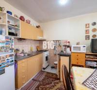 Konyha egy kétszobás lakásban konyhabútorral, háztartási gépekkel és dekorációs tárgyakkal.