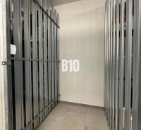 Rácsos tárolóhely betonpadlóval egy kétszobás lakásban.