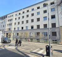 Épület a Bezručova utcában, Pozsony óvárosában - homlokzat ablakokkal és gyalogosokkal.