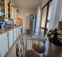 Konyha egy kétszobás lakásban pulttal, konyhaszekrénnyel és üvegasztallal.