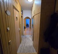 Folyosó egy kétszobás lakásban fa fallal és csempével a padlón.