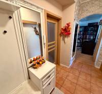 3 szobás lakás belső tere téglaburkolattal, tükörrel és fa dekorációjú padlóval.