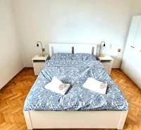 Hálószoba egy háromszobás lakásban ággyal, szekrényekkel és fa dekorációjú padlóval.