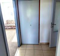 Csempézett folyosó a háromszobás lakásban a szőnyeges szoba mellett.