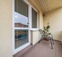 A Veltlínska utcai kétszobás lakás erkélye Pezinkben, virággal és székkel.