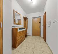 Előszoba egy kétszobás lakásban csempével és fa bútorokkal.