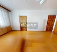 Szoba egy háromszobás lakásban fa dekoros padlóval, nagy ablakkal és beépített szekrénnyel.