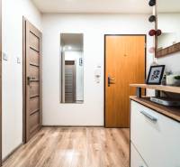 Folyosó egy 2 szobás lakásban fa dekoros padlóval és dekorációkkal.