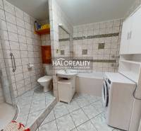 Fürdőszoba egy kétszobás lakásban káddal, zuhanyzóval és mosógéppel.