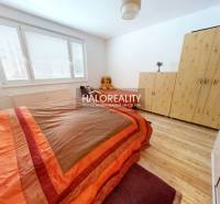 Hálószoba egy kétszobás lakásban ággyal, szekrénnyel és fa dekorációjú padlóval.