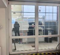 Üveg tolóajtók üzlethelyiségekben, kerékpár, radiátor és műanyag fólia a falon.