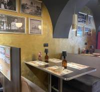 Gasztronómiai terek belső kialakítása fa dekorációval és történelmi fényképekkel a falakon.