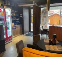 Gasztronómiai tér belső része kör alakú asztallal, székekkel és világítással.