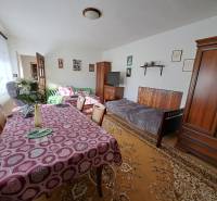 Nappali egy családi házban bútorokkal, étkezőasztallal és dekorációkkal.