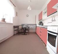 Konyha családi házban piros szekrényekkel és étkező sarokkal.